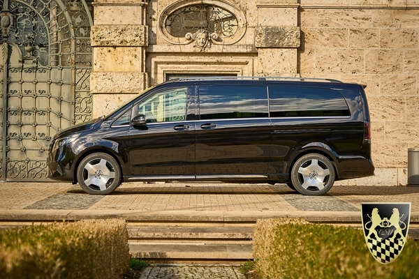 A VIP van parked in front of a scenic Bavarian landscape.